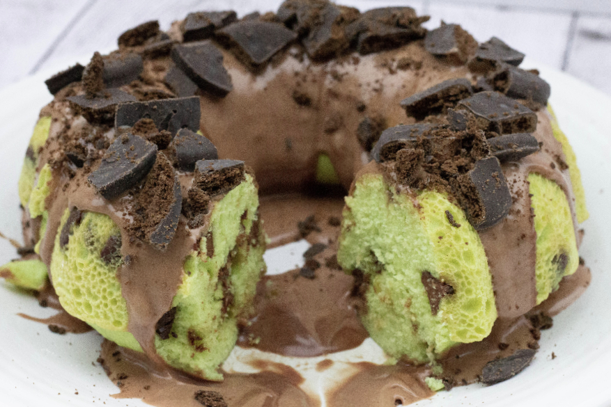 mint chocolate chip bundt cake topped with chocolate glaze and Thin Mint or Grasshopper cookies