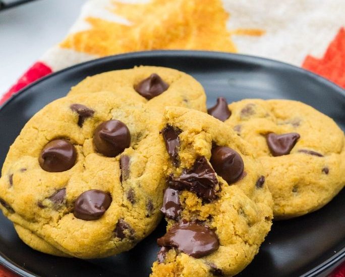 four pumpkin chocolate chip cookies on a plate