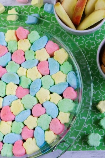 a baking dish filled with Lucky Charms Smores, next to some dippers