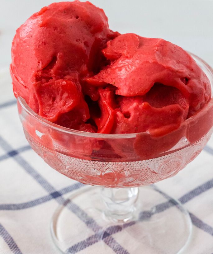 scoops of ninja creami strawberry sorbet served in a glass dish