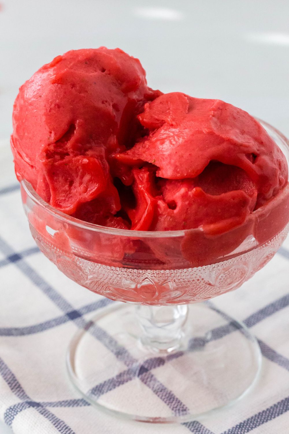 close-up view of a few scoops of strawberry sorbet that was made in the Ninja Creami ice cream maker, served in a glass dessert cup