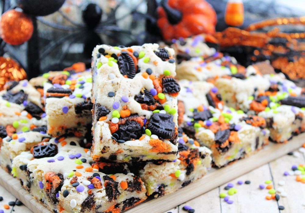 Halloween dessert bars made with Oreos, served on a wooden cutting board