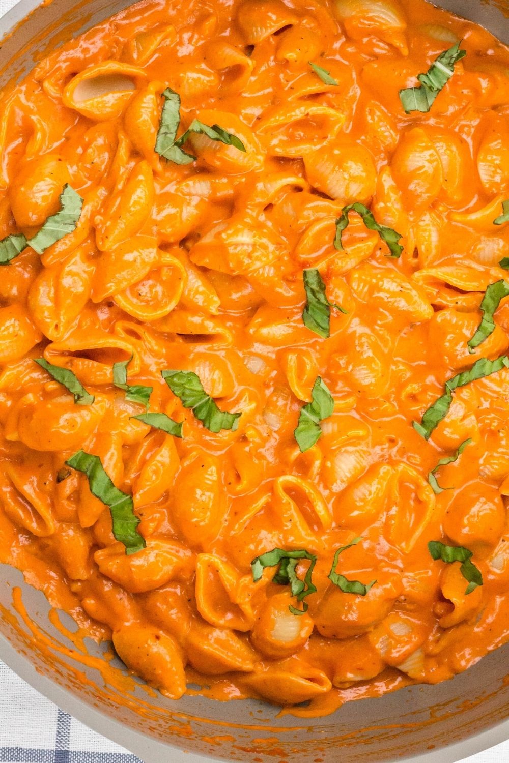 overhead view of a saucepan filled with Gigi Hadid's vodka pasta in a creamy tomato sauce with basil