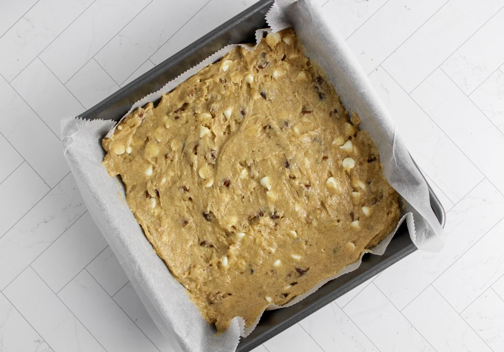 8x8" pan lined with parchment paper and filled with batter for eggnog blondies